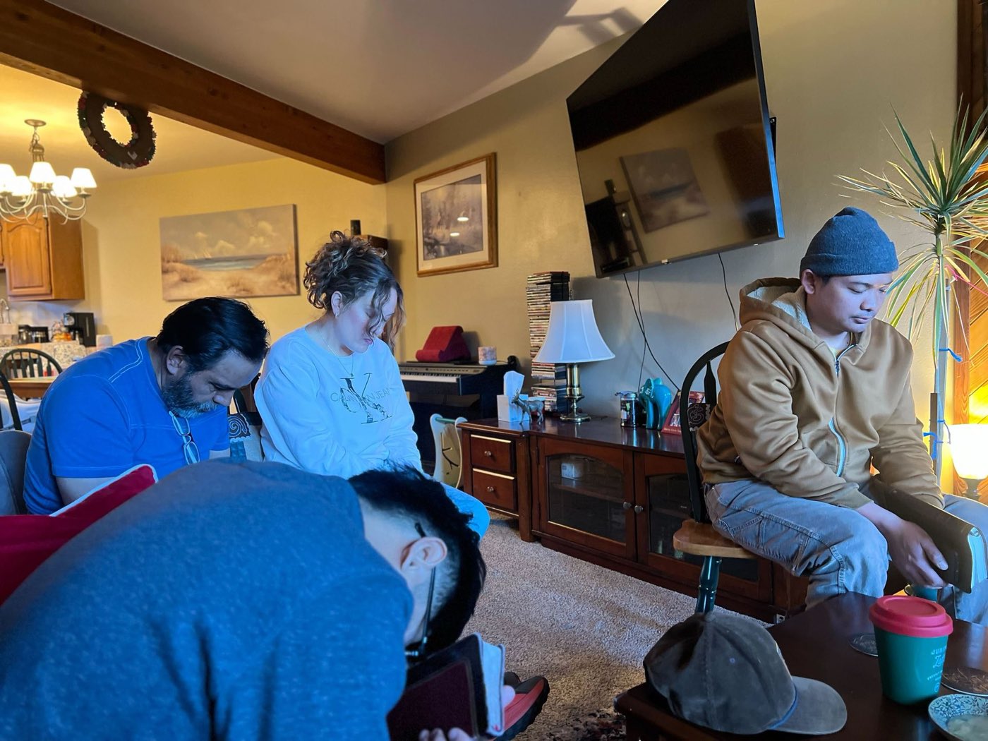 Members of Summit Bible Baptist Church praying together during a home Bible study